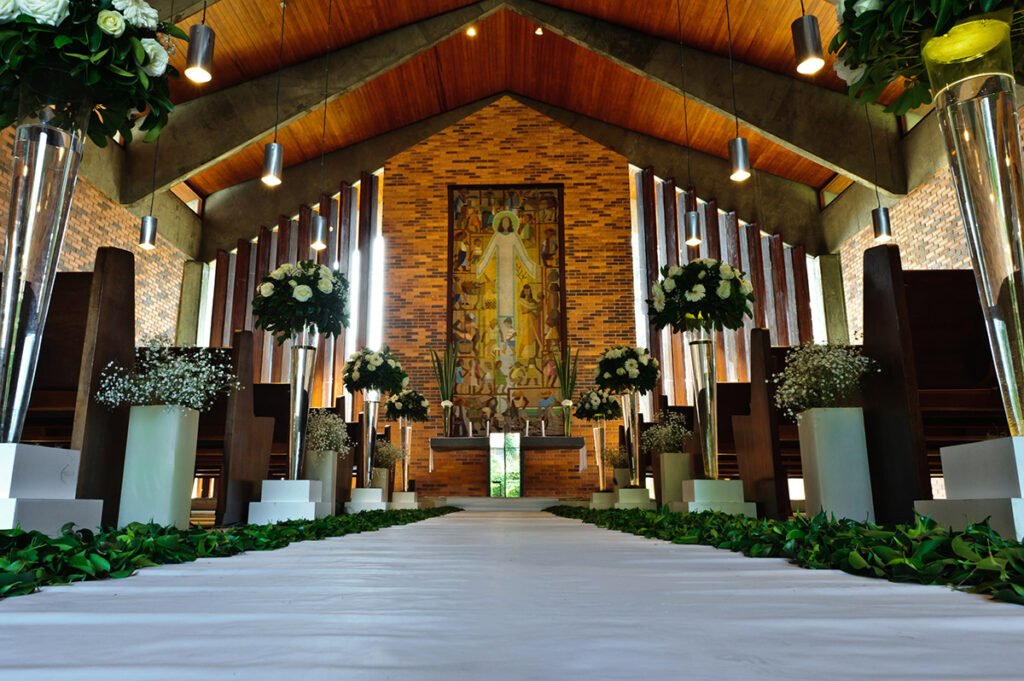 Igreja com decoração floral e caminho branco para casamento